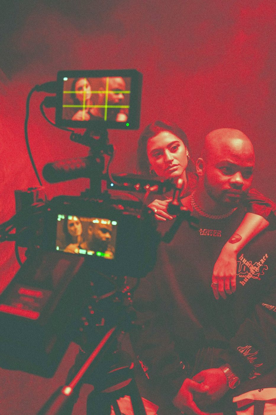 A creator and their crew on set, lit red, with a camera rig in front